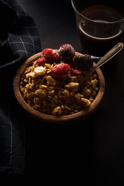 Ahududu ve böğürtlen Kupası ahşap kase kahve siyah masada granola 