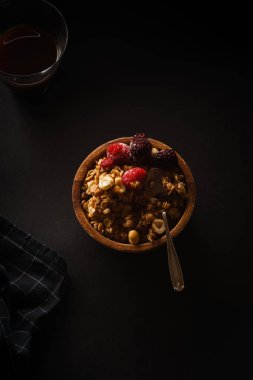 Ahududu ve böğürtlen Kupası ahşap kase kahve siyah masada granola 
