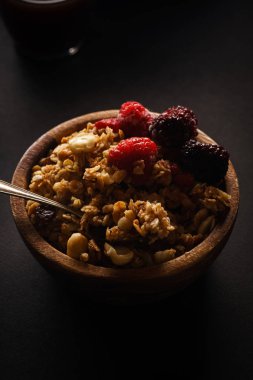 Granola ahududu ve böğürtlen ahşap kase ile. Üstten görünüm,