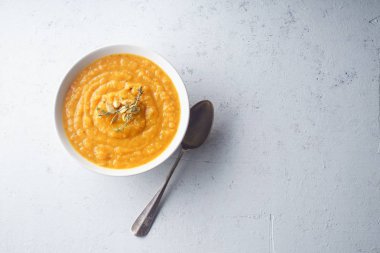 Tohum ve kekik kase beton zemin üzerine kaşıkla püresi kabak çorbası. Sıcak yiyecek konsepti, diyet