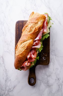 Jambon ve ahşap kesme tahtası üzerinde taze marul ile domates taze baget sandviç Banh'da-mi tarz 