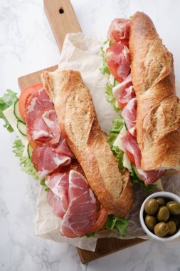 Jambon ve ahşap kesme tahtası üzerinde taze marul ile domates taze baget sandviçler Banh'da-mi tarz 