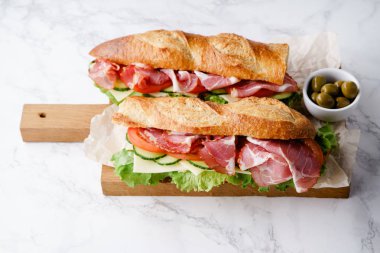 Jambon ve ahşap kesme tahtası üzerinde taze marul ile domates taze baget sandviçler Banh'da-mi tarz 