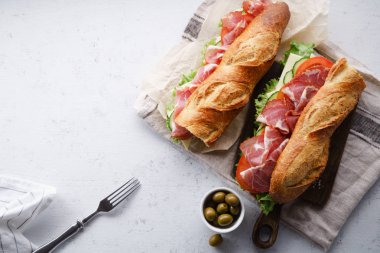 iki taze baget sandviçler Banh'da-mi tarz ile jambon ve peynir domates ve taze marul beton zemin üzerine dilimlenmiş 