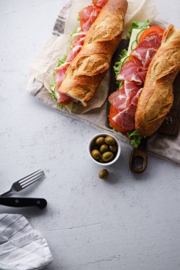 iki taze baget sandviçler Banh'da-mi tarz ile jambon ve peynir domates ve taze marul beton zemin üzerine dilimlenmiş 