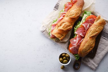 iki taze baget sandviçler Banh'da-mi tarz ile jambon ve peynir domates ve taze marul beton zemin üzerine dilimlenmiş 