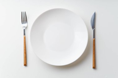 Bıçak ve beyaz arka plan üzerinde üstten görünüm izole çatal ile beyaz boş levha  