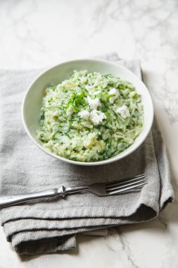 Ispanak risotto çatal ve peçete mermer zemin üzerine