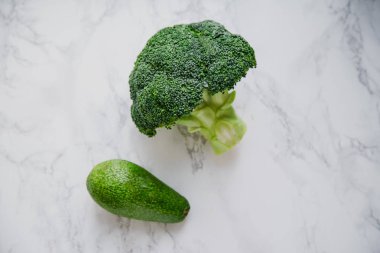 Taze yeşil avokado ve brokoli mermer masada 