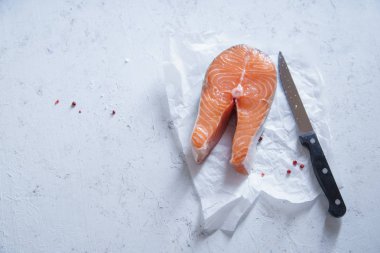 Biftek beton zemin üzerine bıçakla çiğ somon 