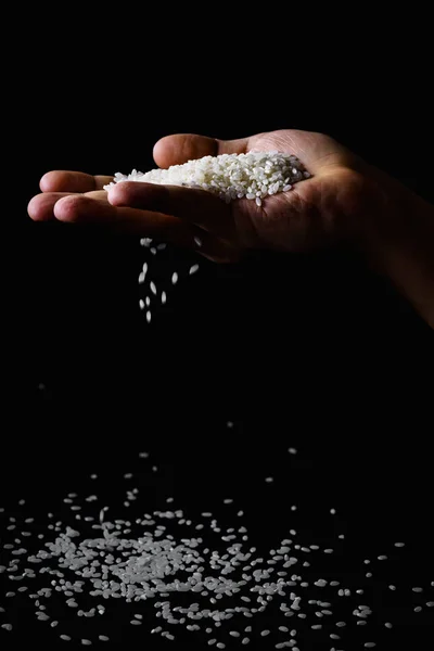 Arroz Caindo Através Dedos Mão Masculina Fundo Escuro — Fotografia de Stock