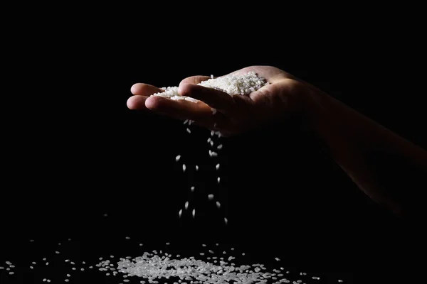 Reis Fällt Durch Finger Der Männlichen Hand Auf Dunklem Hintergrund — Stockfoto