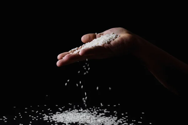 Arroz Caindo Através Dedos Mão Masculina Fundo Escuro — Fotografia de Stock