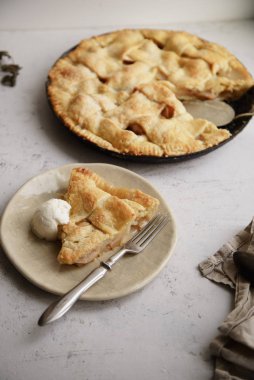 Elmalı turta kafes süsleme ve el yapımı seramik vanilyalı dondurma kaşık ile tabakta dilim ile 