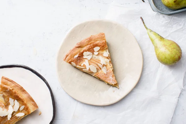 slices of tart with poached pears and almond frangipane on plates