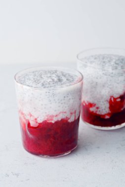 Chia puding ile ışık arka plan üzerinde çilek güler yüzlü iki bardak 