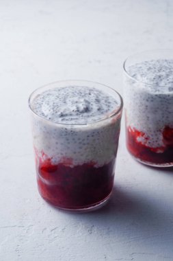 Chia puding ile ışık arka plan üzerinde çilek güler yüzlü iki bardak 