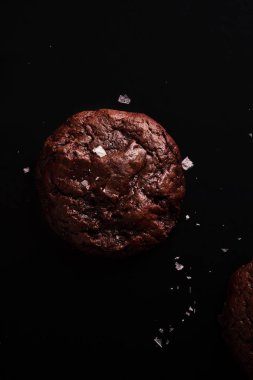 koyu arka plan üzerine tuz pul ile yumuşak çikolatalı kurabiye 