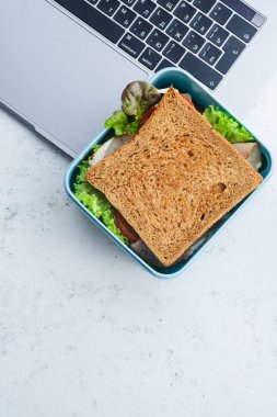 Laptop plastik kap içinde Yeşiller ve jambon ile sağlıklı sandviç Paketli. İş yerinde öğle yemeği için paket servisi olan restoran gıda 