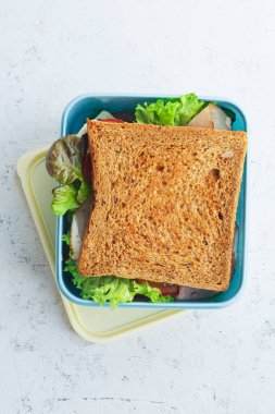 Yeşiller ve jambon ile sağlıklı sandviç plastik kap içinde Paketli. İş yerinde öğle yemeği için paket servisi olan restoran gıda 