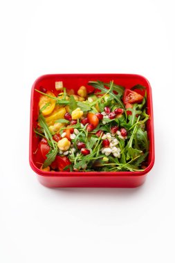 Tahıl ve nar taneleri beyaz zemin üzerine kırmızı plastik kap içinde salatası. Ofis öğle yemeği kavramı