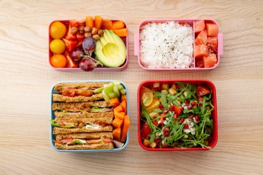 Bento kutular ahşap masa üzerinde sağlıklı öğle yemekleri ile yaratıcı düzeni. Günlük ofis öğle yemeği kavramı