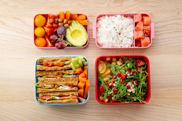 Bento kutular ahşap masa üzerinde sağlıklı öğle yemekleri ile yaratıcı düzeni. Günlük ofis öğle yemeği kavramı