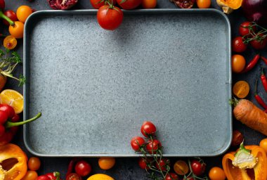 Beton gri arka planda boş metalik tepsi ile taze renkli sebze yığını, sağlıklı gıda maddeler kavramı