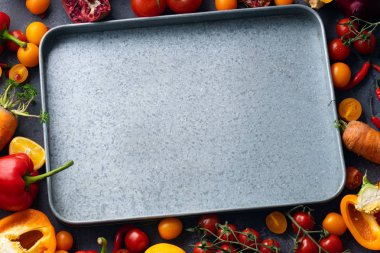 Beton gri arka planda boş metalik tepsi ile taze renkli sebze yığını, sağlıklı gıda maddeler kavramı