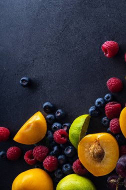 karanlık arka planda taze meyve ve çilek. Vegan beslenme konsepti 