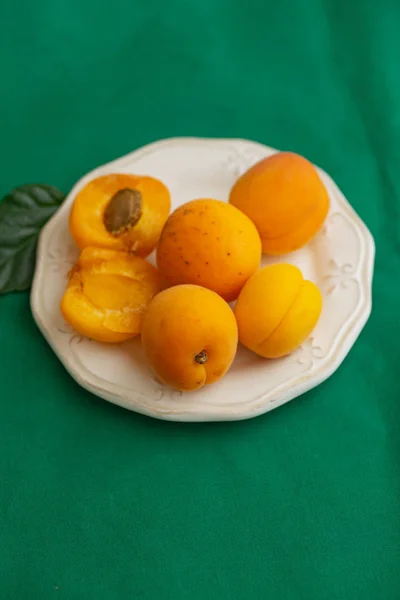 Pile Orange Sweet Apricots Porcelain Plate Dark Green Tablecloth — Stock Photo, Image