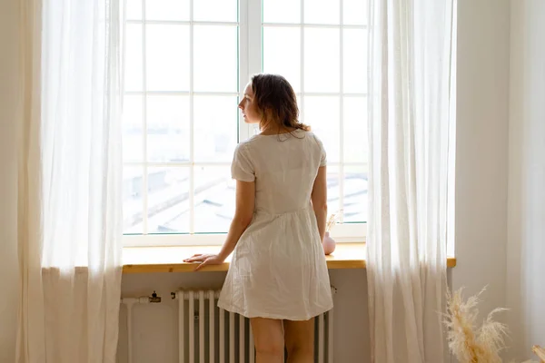 Young Woman Looking Window Glass While Standing Bedroom Early Morning — 스톡 사진