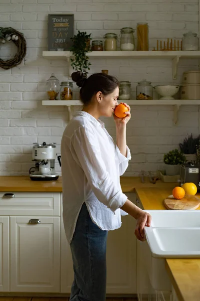 Młoda Kobieta Pachnąca Pomarańczowo Stojąc Kuchni — Zdjęcie stockowe