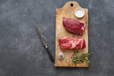 Sarımsak ile biberiye ve deniz tuzu ile vintage kesme tahtası üzerinde Çiğ siyah angus prime sığır biftek 