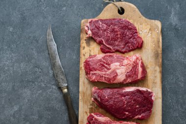 Vintage kesme tahtası üzerinde Ham siyah angus prime sığır eti biftek çeşitli 