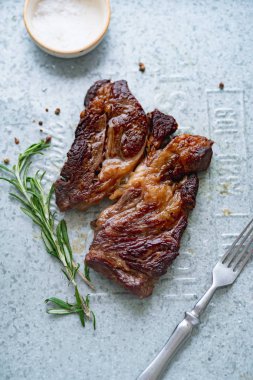 Pişmiş siyah angus prime sığır eti biberiye ve metalik tepsiüzerinde deniz tuzu ile kase ile biftek