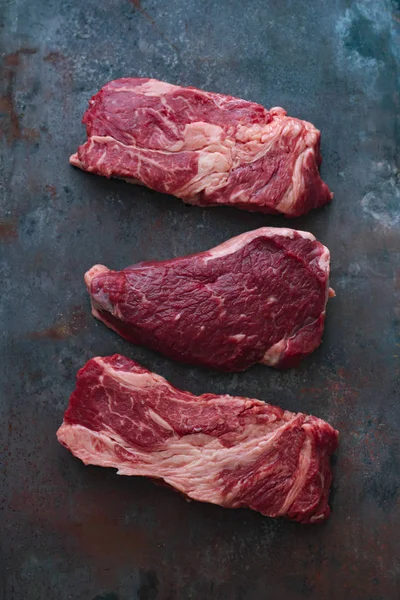 Koyu metalik arka plan üzerinde Ham siyah angus prime sığır eti biftek çeşitli