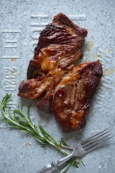 Metalik tepside biberiye ile pişmiş siyah angus prime sığır eti biftek