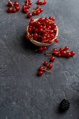 koyu beton arka planda kase kırmızı kuş üzümü. Üst görünüm 