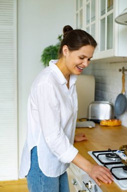 Mutfak soba yakın beyaz gömlek ayakta mutlu gülümseyen kadın 