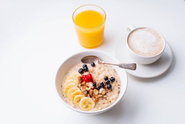 Masada portakal suyu bardağı ile çilek ve kahve fincanı ile yulaf ezmesi ile kahvaltı 