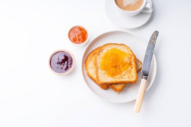 sabah tost ve kase ile plaka confitures ve beyaz masada sıcak kahve fincanı ile