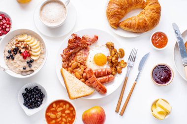 beyaz arka plan üzerinde kızarmış tost ve reçel ile yulaf ezmesi ve çilek ile pastırma ve sosis ile kızarmış yumurta 