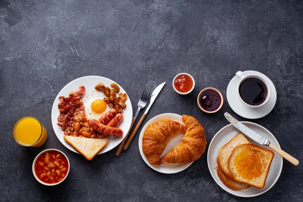 베이컨 튀김과 달걀을 곁들인 클래식한 영국식 크루아상 커피가 배경에 제공됩니다 — 스톡 사진