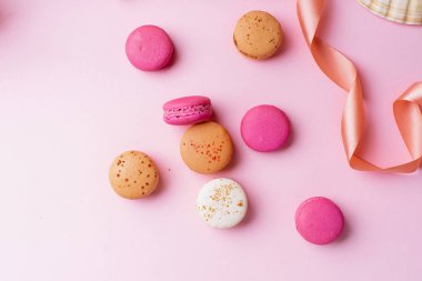 pembe arka plan üzerinde tatlı renkli macaroons. Üstte görüntü
