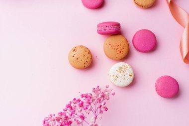 pembe arka plan üzerinde tatlı renkli macaroons. Üstte görüntü