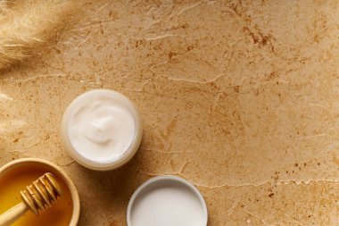 Küçük kapta krem ile traverten arka plan üzerinde Spa güzellik cilt bakımı mock-up. Üstte görüntü 