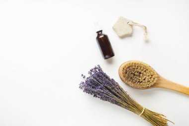 Vücut fırçası ve serum ve lavanta çiçekleri ile beyaz arka plan üzerinde Spa güzellik cilt bakımı flatlay. Üstte görüntü 