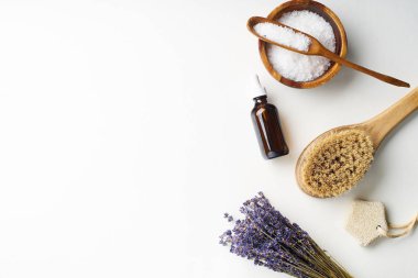 Spa güzellik cilt bakımı flamock-up vücut fırçası ve serum ve tuz ve lavanta çiçekleri ile kase ile beyaz arka plan üzerinde yatıyordu. Üstte görüntü
