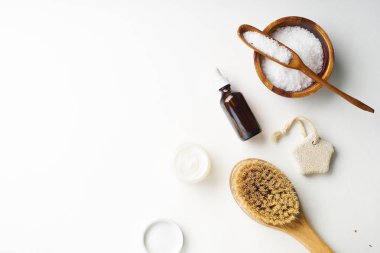 Spa güzellik cilt bakımı flamock-up vücut fırçası ve serum ve tuz ile kase ile beyaz arka plan üzerinde yatıyordu. Üstte görüntü